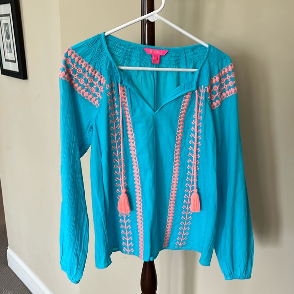 Bright turquoise and peach top that would look great with white jeans
